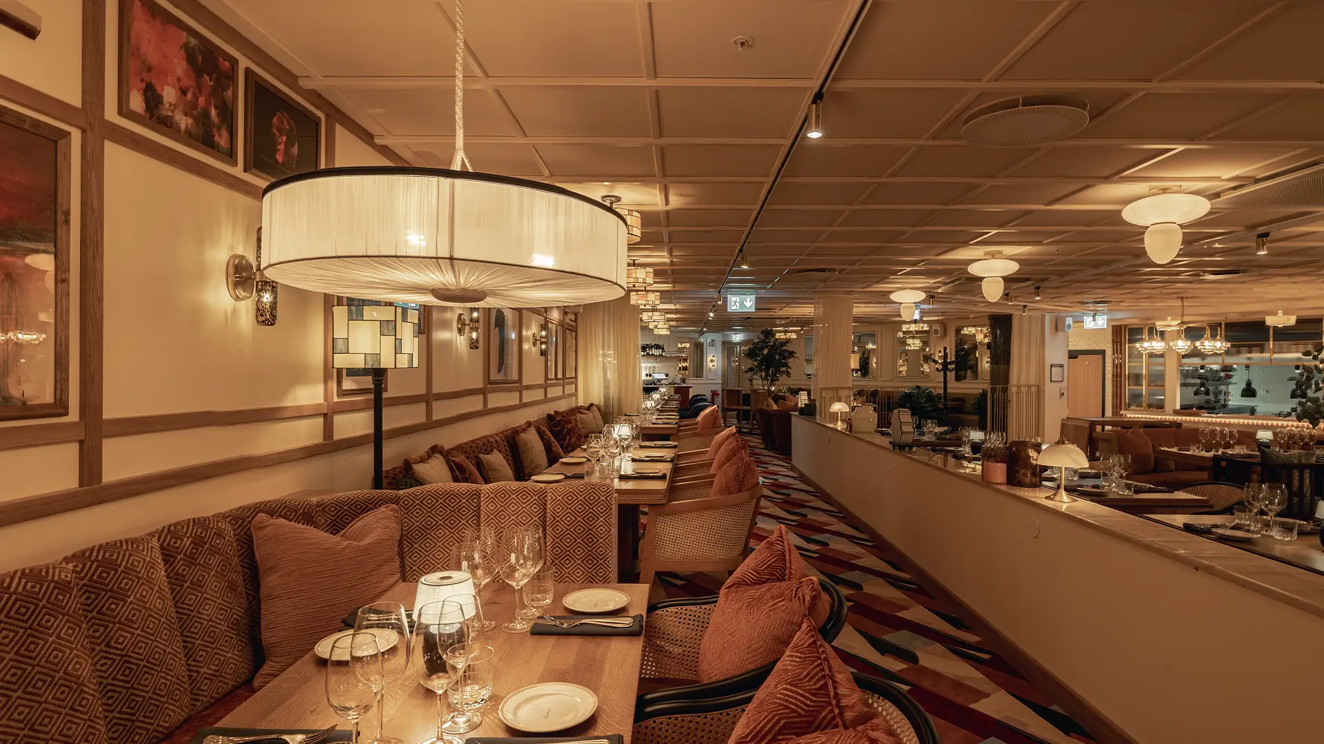 Archies-american-restaurant Elegant restaurangmiljö med dämpad belysning, dukade bord och mjuka soffor på Archie's i Göteborg.