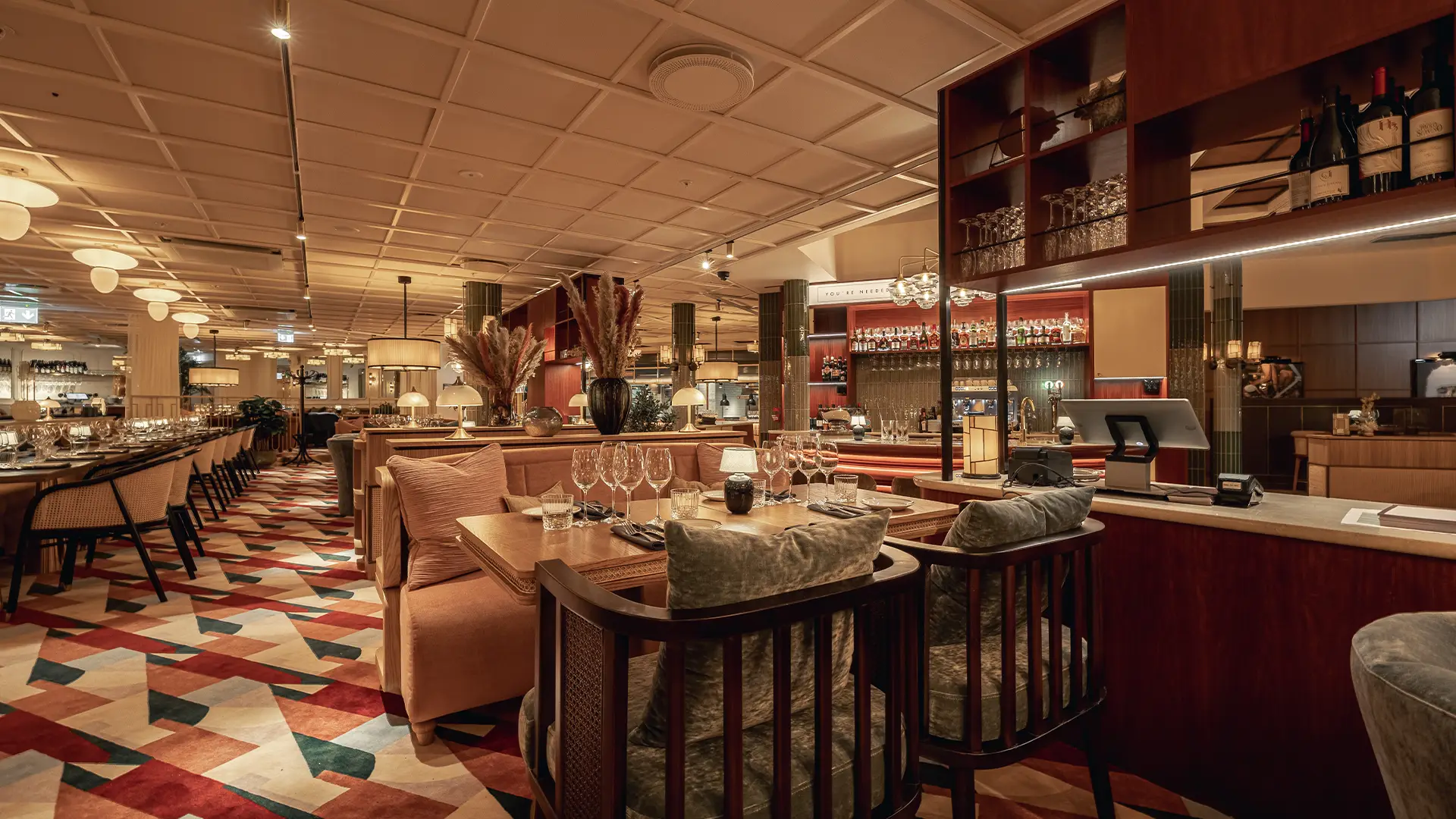 Interiör från Archie’s restaurang i Göteborg med färgstark matta, uppdukade bord och varm belysning.